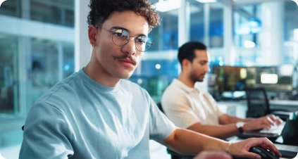 Two developers working side by side at their desks